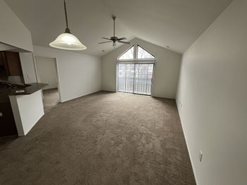 A large living room with a cathedral ceiling in a Juniper style apartment